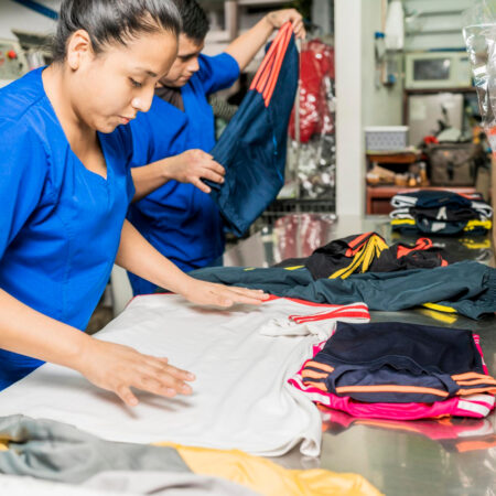 trabajadores-uniformados-doblando-ropa-servicio-lavanderia(1)